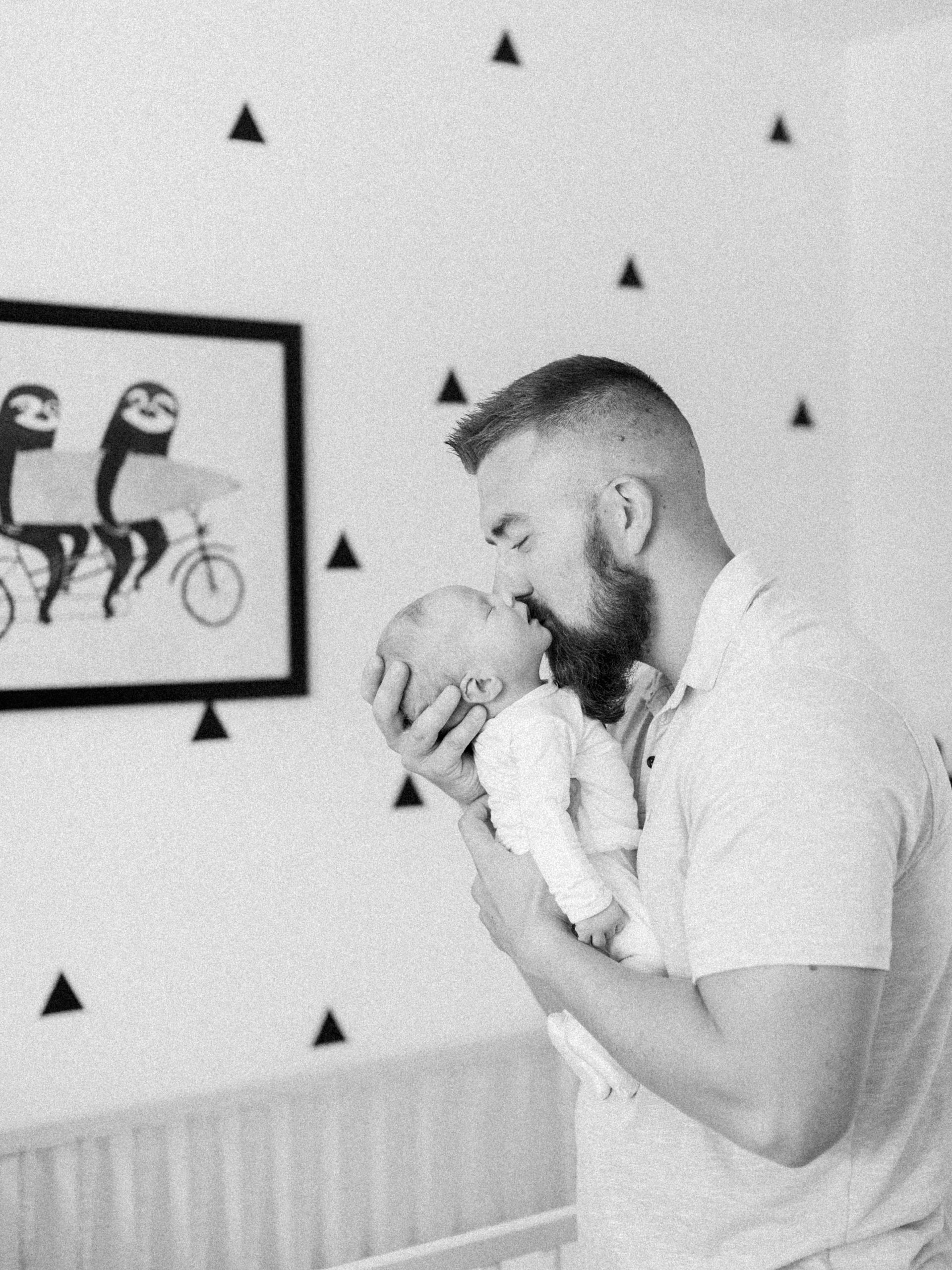 yuma-newborn-photographers-father-kissing-newborn-baby-in-home-portrait